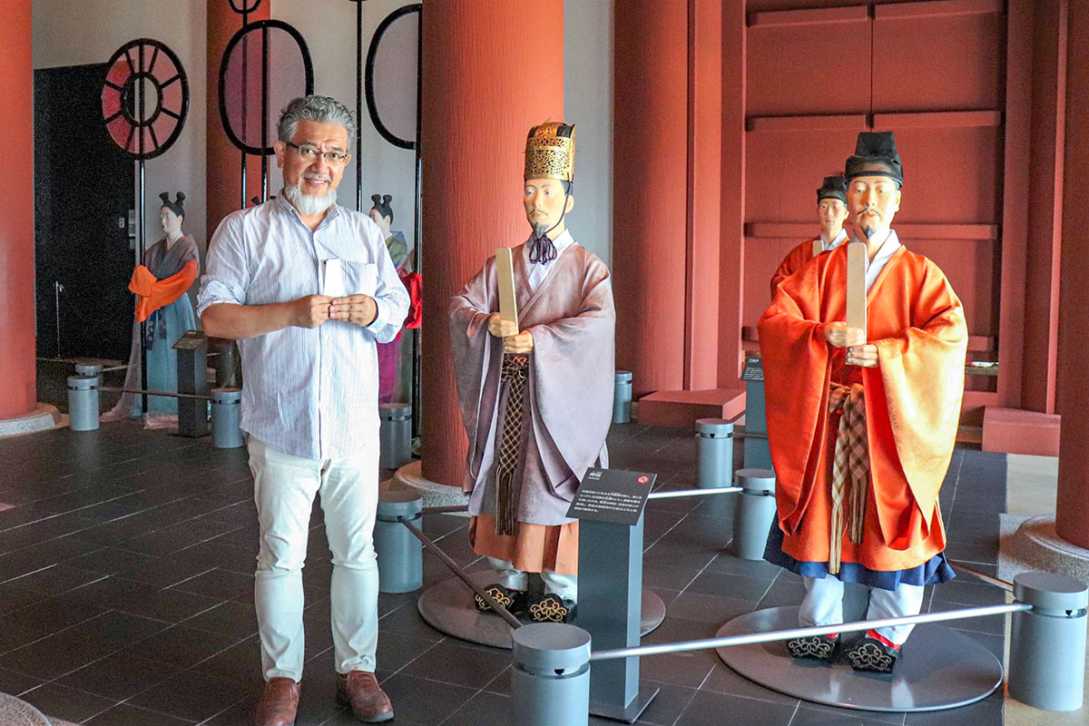 大阪歴史博物館の展示人形の笏の持ち方を教える三宅善信代表
