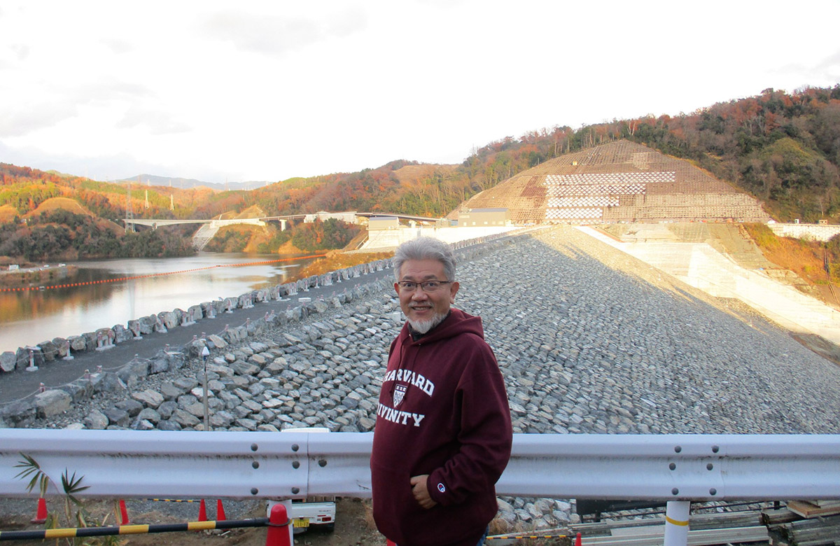 完成間近のロックフィルダムを見学する三宅善信代表